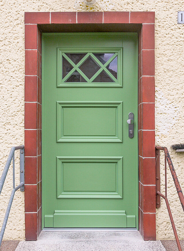 Nachgebaute Haustür in Königs Wusterhausen mit speziellem Sockel, profilierten Füllungen und besonderem Sprossenfeld in der oberen Verglasung