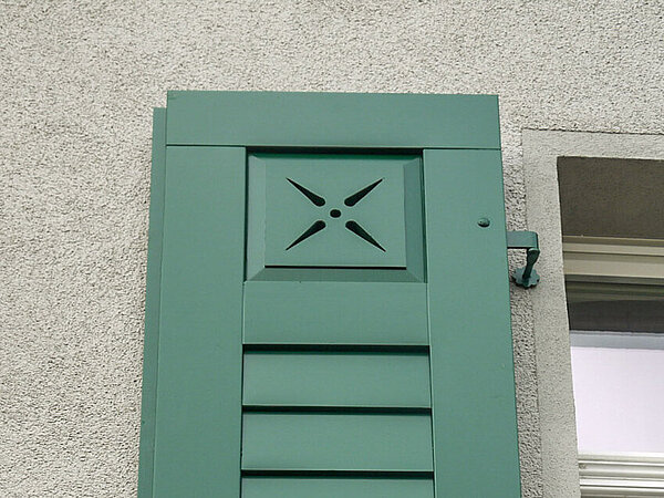 Das Querstück verläuft über die komplette Breite. Detailaufnahme Fensterladen mit Stülpschalung