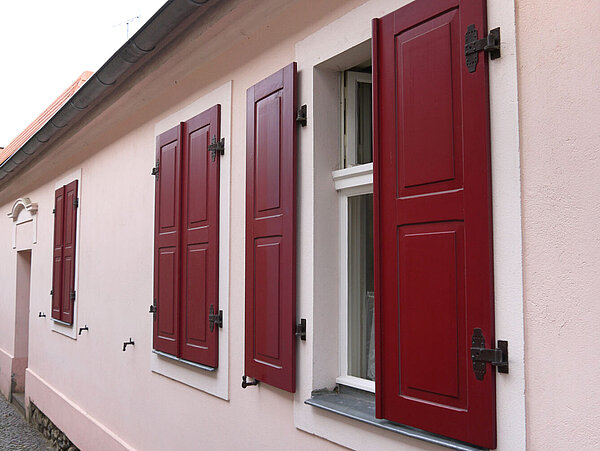 Kasettenladen, die Füllungen sind beidseitig abgeplattet ( = Fachbegriff für die umlaufende Vertiefung an der Füllung) Rote Fensterläden