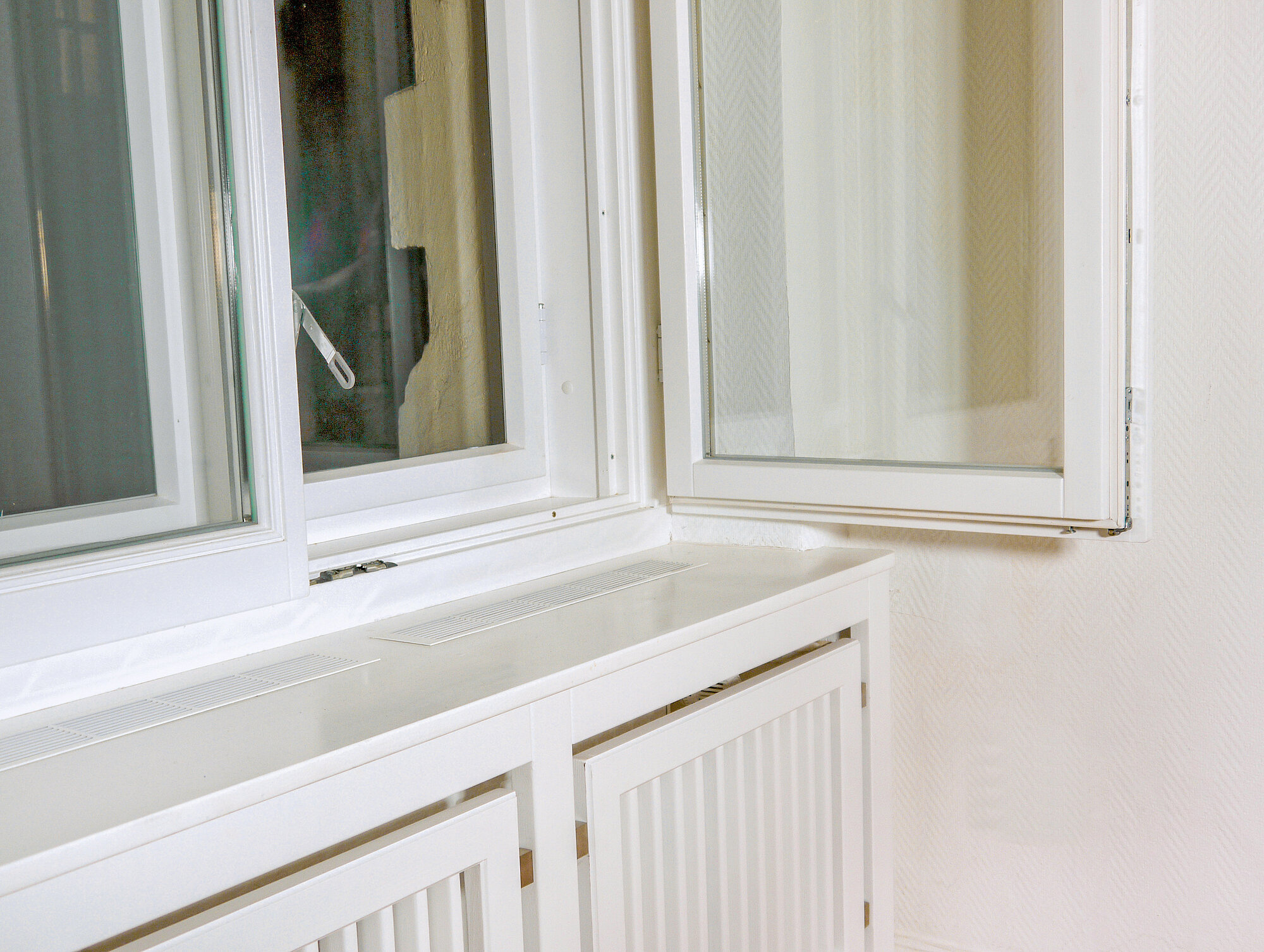 Wohnung Berlin: Innen modernes Isolierglas, außen Einfachverglasung, unten passend die Heizungsverkleidung